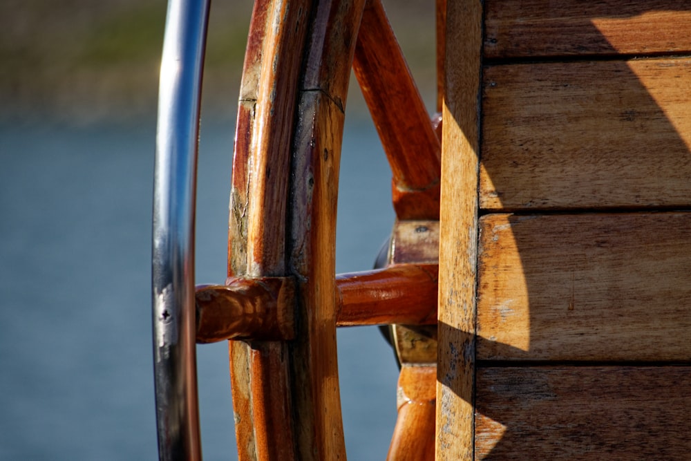 a close up of a wooden wheel on a boat