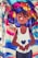 A vibrant street art mural featuring a cartoon-style character with large, colorful hair in shades of blue, purple, yellow, and pink. The character is depicted with closed eyes, expressing serenity, and holding a heart symbol. The background includes swirling, colorful patterns.