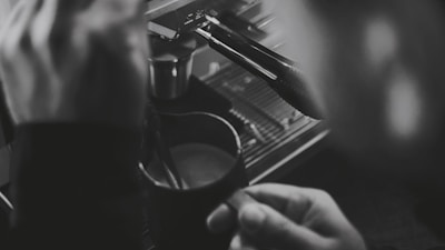 A close-up of a barista preparing coffee with steaming milk.