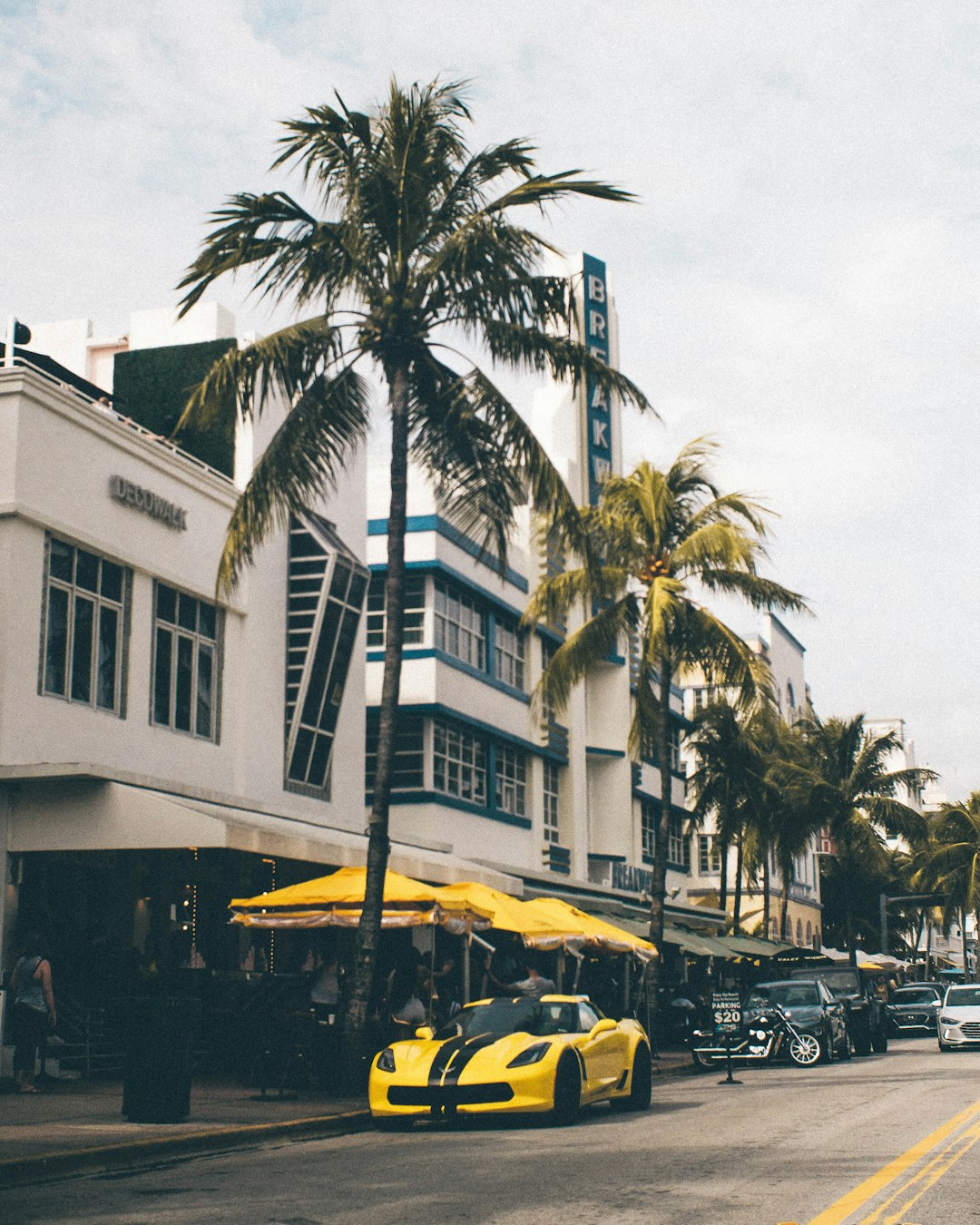 yellow coupe parked on sidewalk in front of establishment