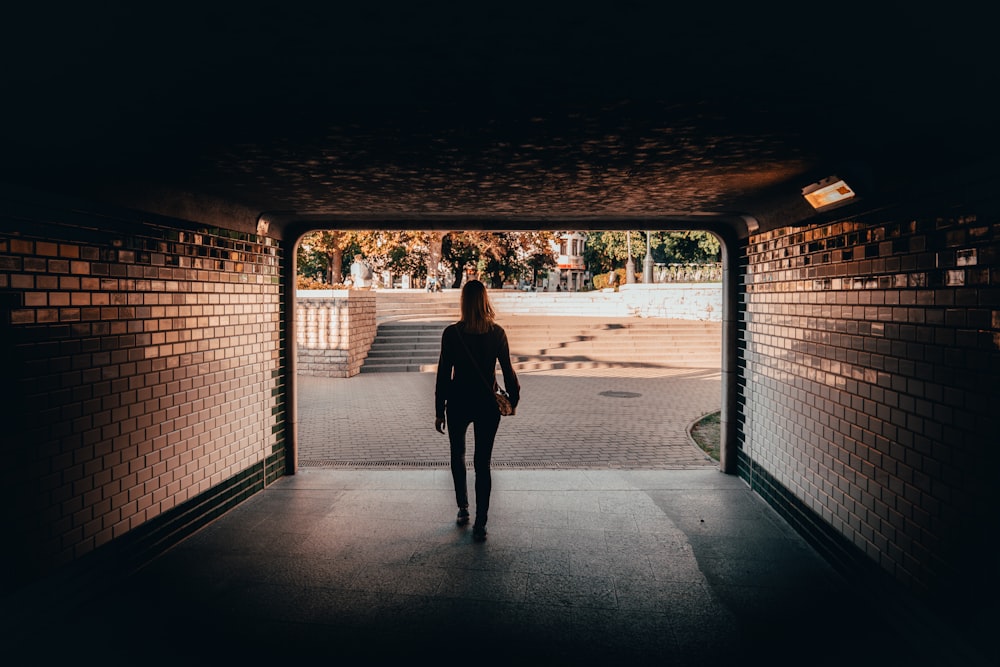 silhouette of woman by gate during daytime