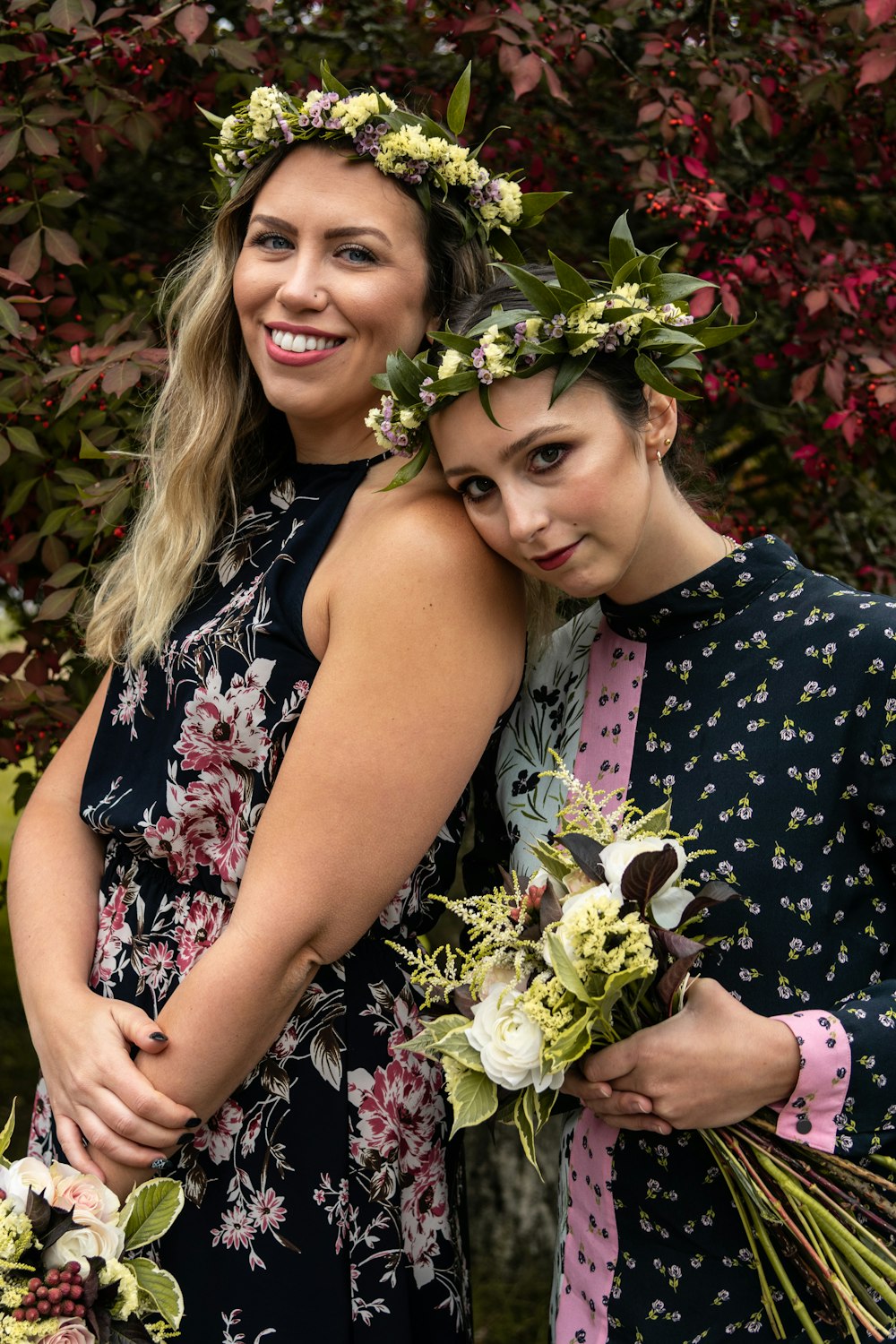 two woman wearing black floral dresses
