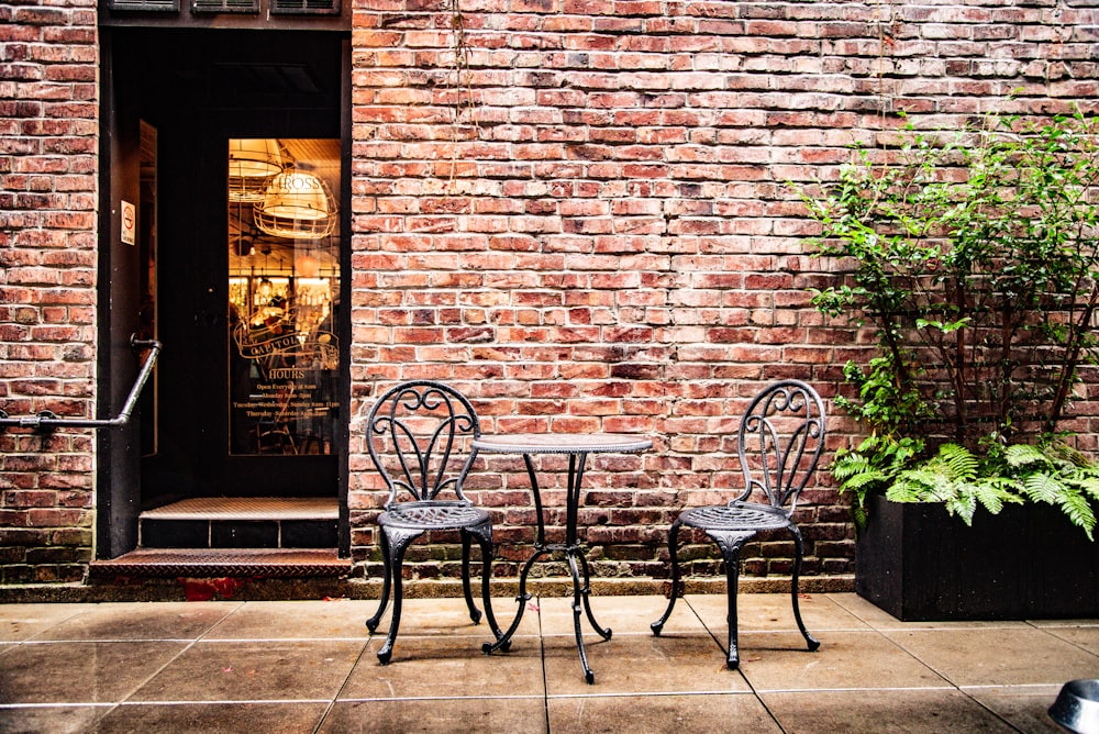 two black empty chairs beside table in front of building