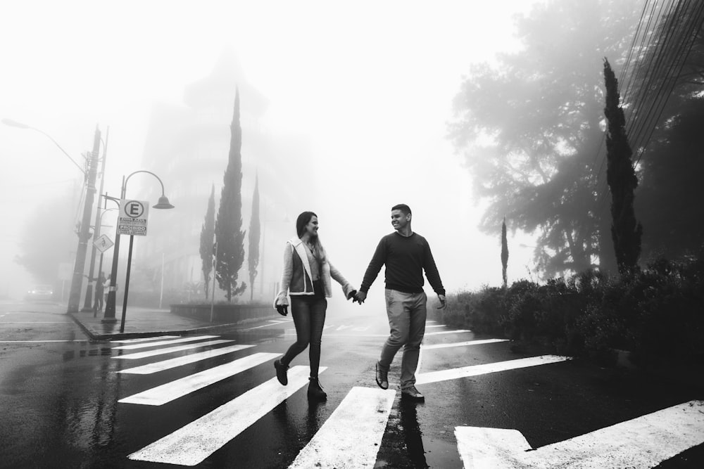 couple hold each other hands while walking on pedestrian lane