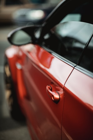 Close-up of a car door before and after expert dent removal and repainting.