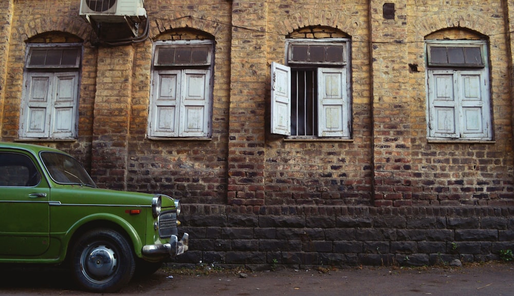 green vehicle near brown concrete house