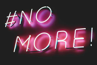 A pop-up style neon sign reading 'No to EV Vehicles' against a dark backdrop.