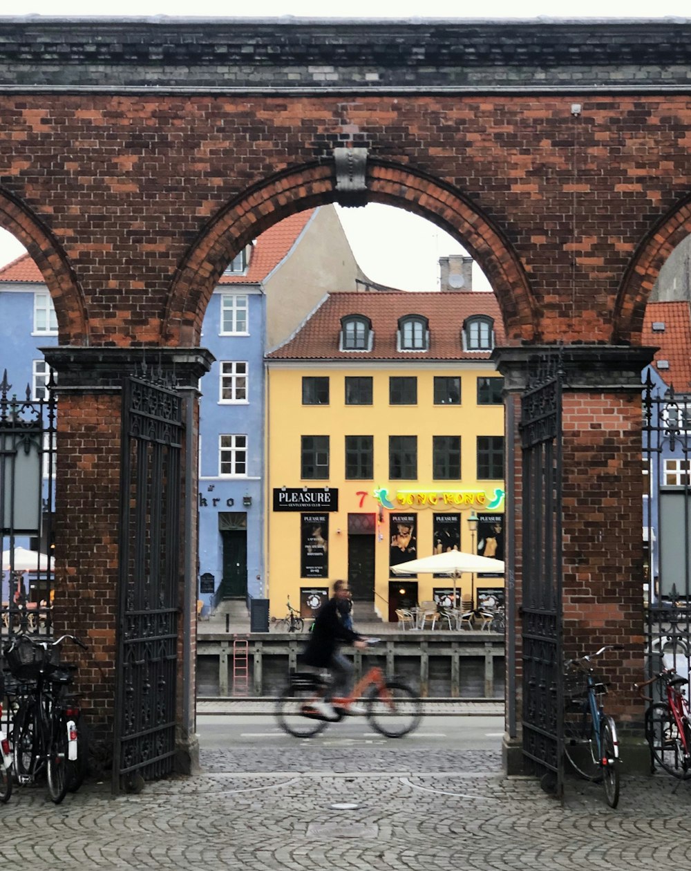 um homem andando de bicicleta por um arco de tijolos