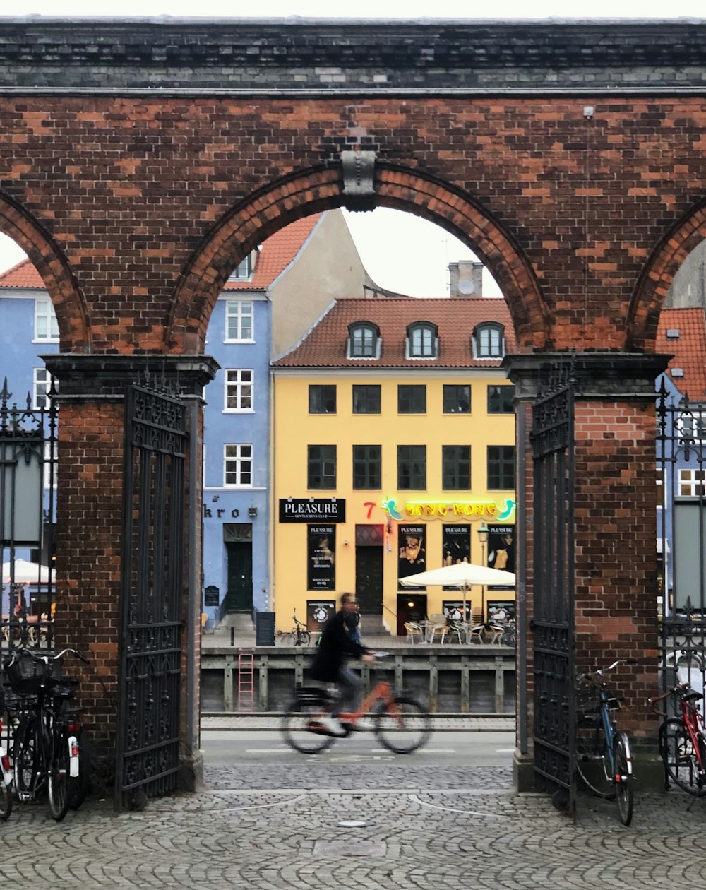 a man riding a bike through a brick archway