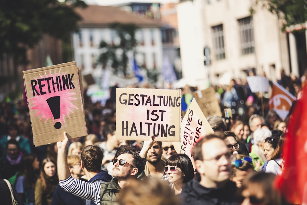 shallow focus photo of person holding signage