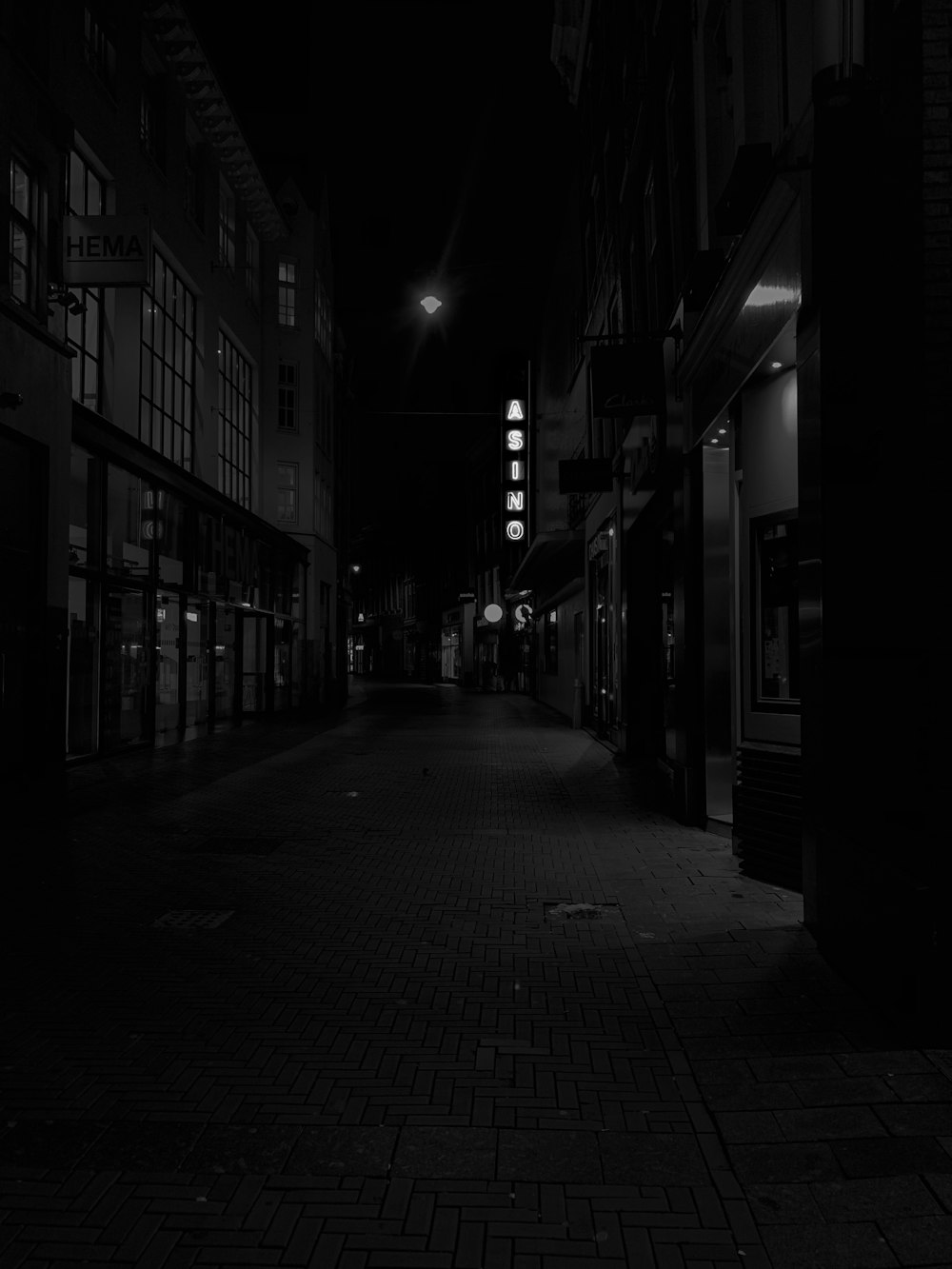 a black and white photo of a street at night