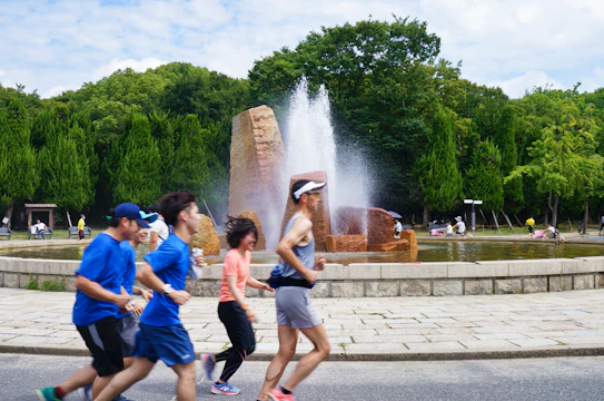 A group of diverse people jogging together in a park, smiling and enjoying the fresh air.
