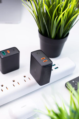 Stack of mobile accessories including chargers and earbuds, arranged neatly with a tropical island backdrop.