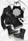 A flat lay of black and white streetwear essentials including a jacket, backpack, and sunglasses.