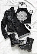 A flat lay of black and white streetwear essentials including a jacket, backpack, and sunglasses.