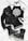 A stylish flat lay of fashion items including a black leather jacket, a black halter top with a white intricate mandala design, black denim shorts, lace-up black combat boots with studs, a pair of black sunglasses, and black bangles. The items are arranged on a white cloth background.
