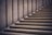 Stone steps leading upward with a minimalist design, featuring smooth, clean lines. The materials used give a sense of solidity and permanence, with a subtle play of light and shadow creating depth.