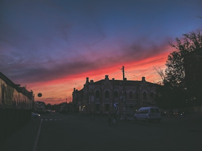 A vibrant colored pencil drawing of a bustling city street scene at dusk.