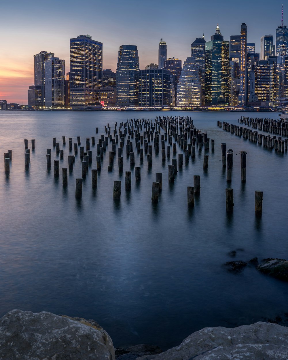 wooden dock post near buildings during golden hour