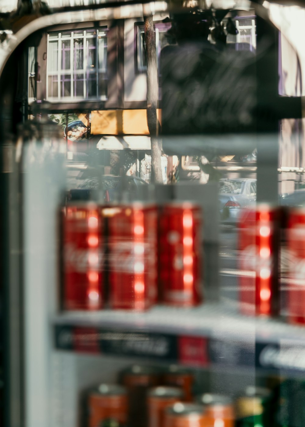 Coca-Cola cans in glass display during daytime