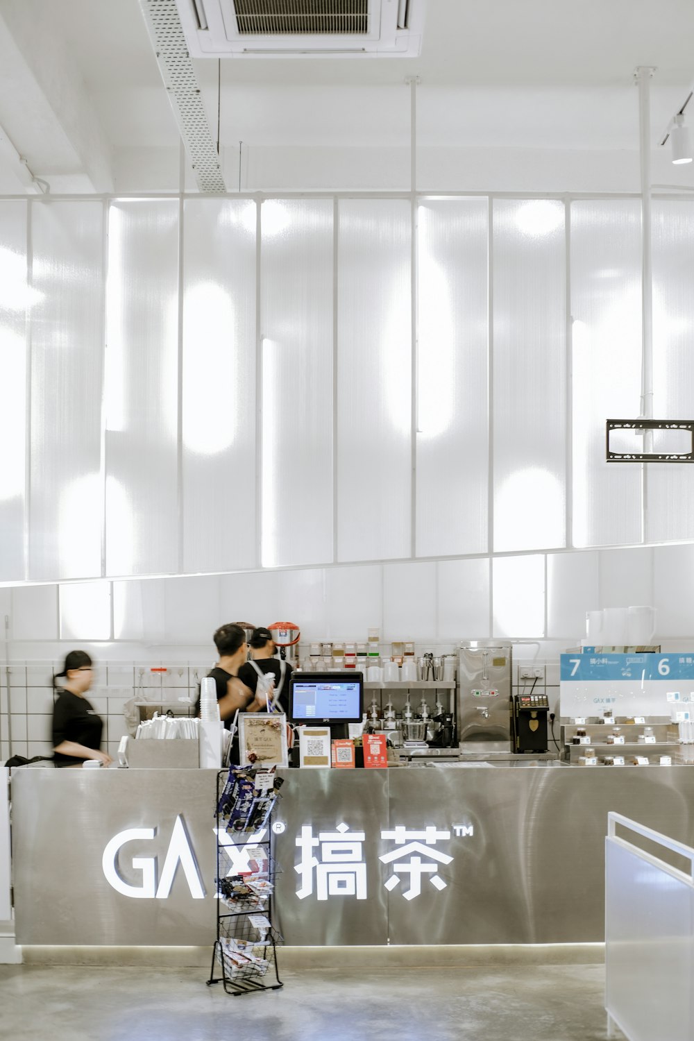 people behind metal panel inside a lighted building