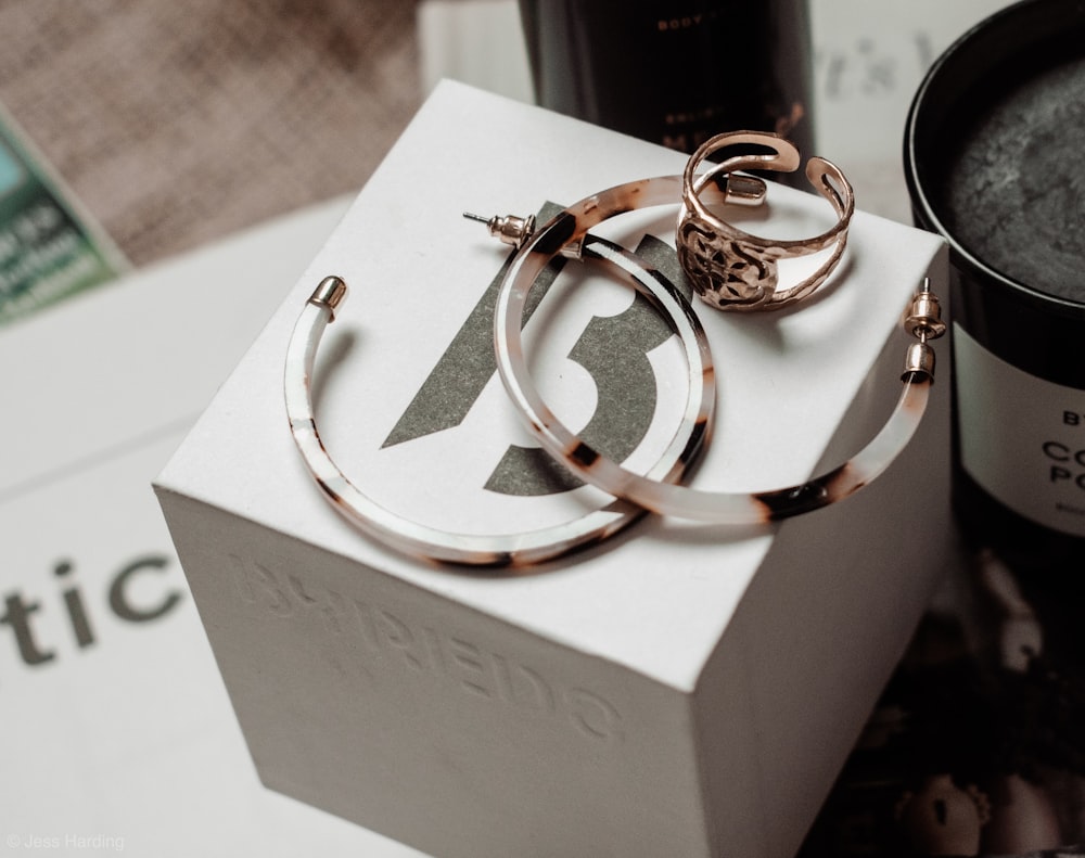 a pair of hoop earrings sitting on top of a box