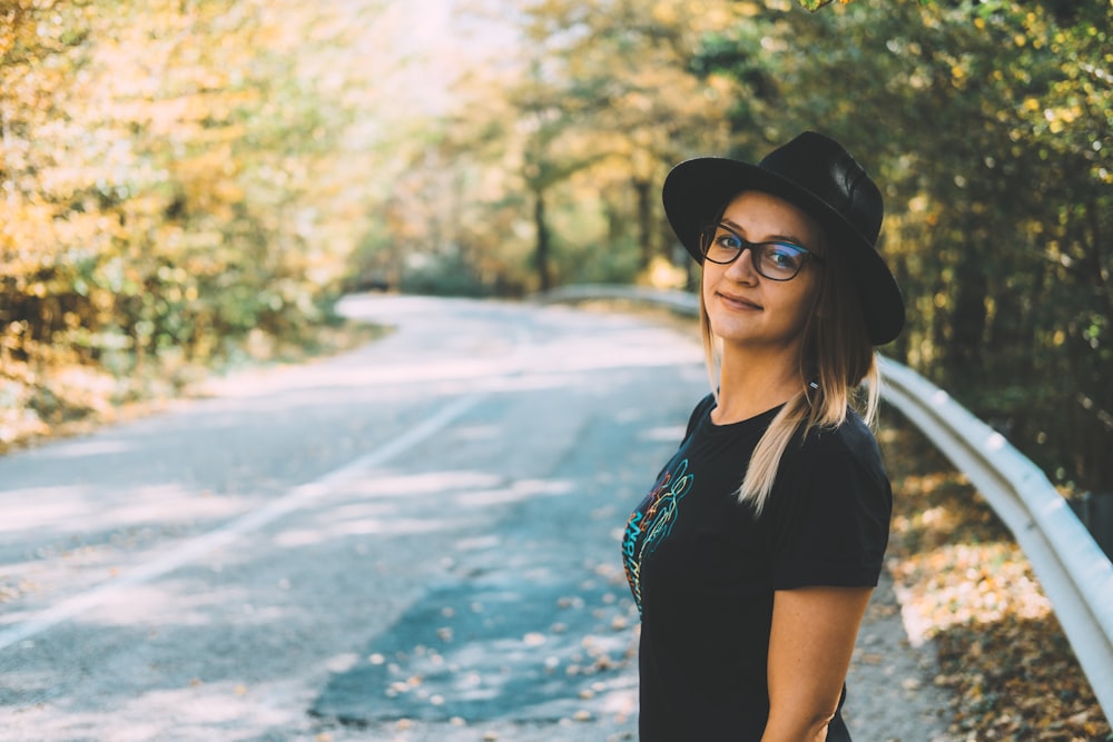 standing woman wearing black shirt on road