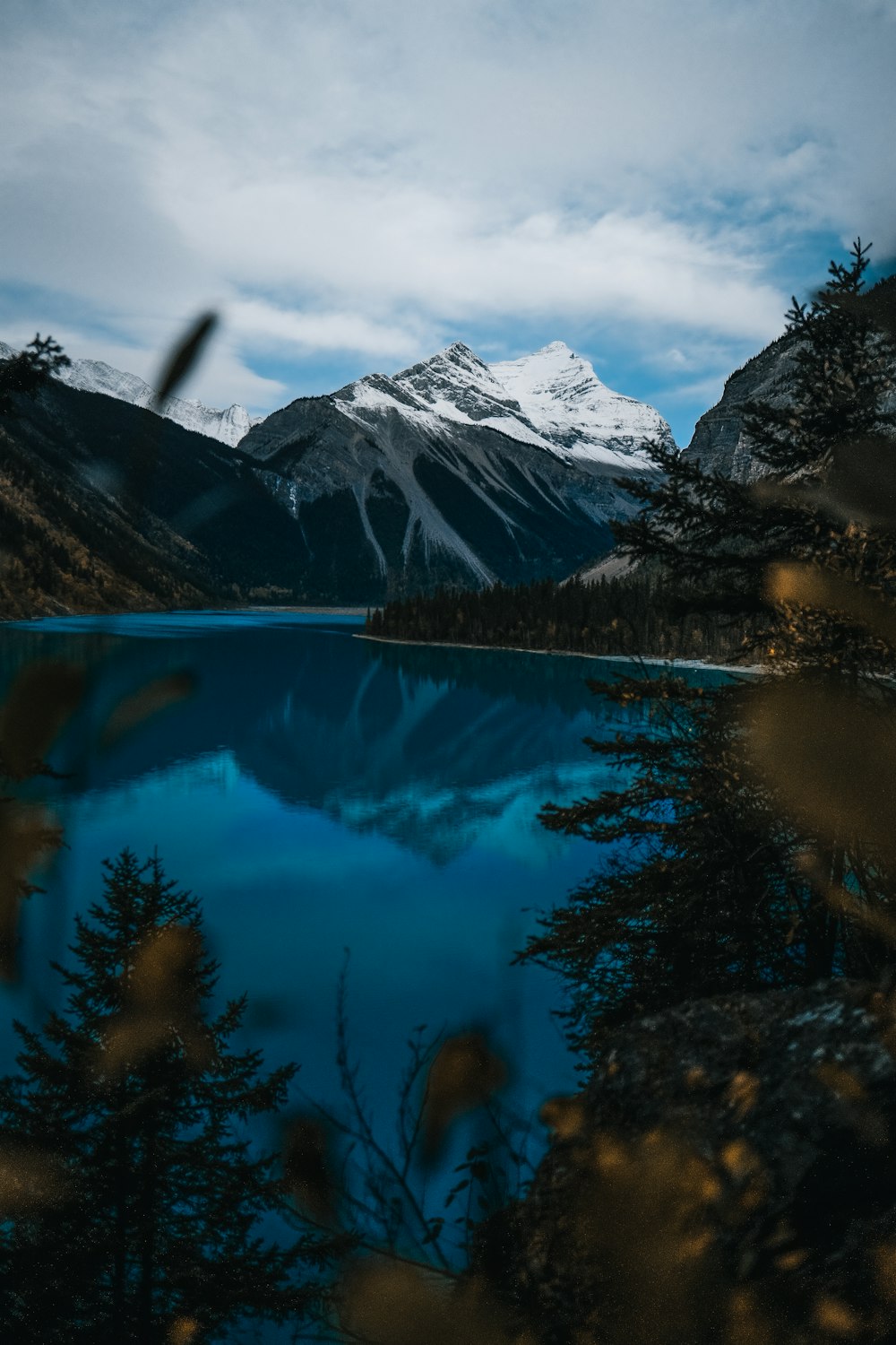 body of water near snow-covered mountain during daytime