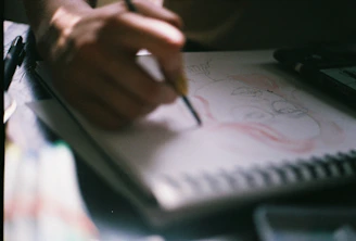 person drawing portrait of woman wearing eyeglasses