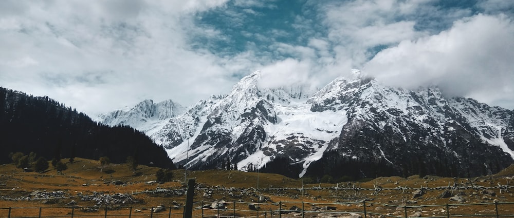 snow covered mountain under cloudy sky