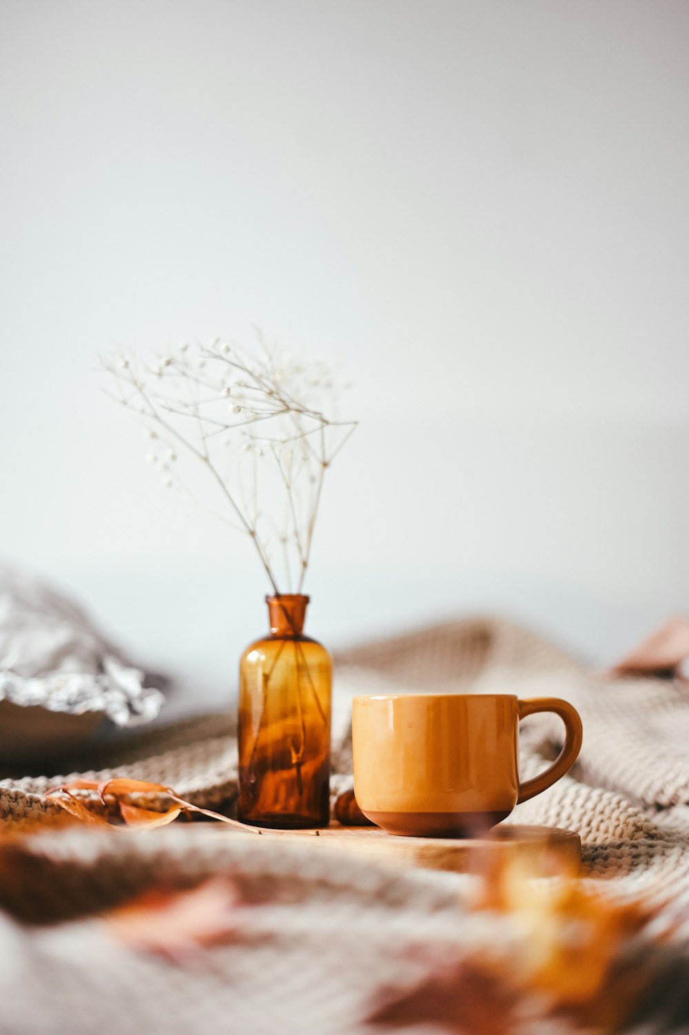 brown mug beside amber vase