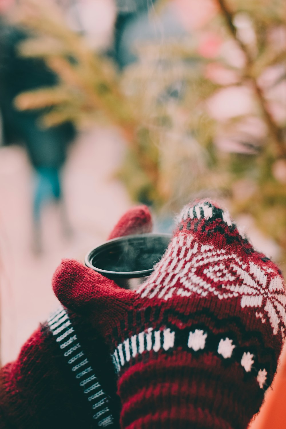 person holding grey and black mug