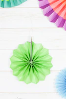 A collection of brisaluz fans in mint green, light pink, and white arranged neatly on a clean white surface.
