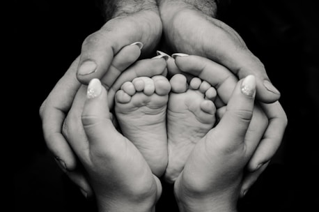 greyscale photography of human feet and hand