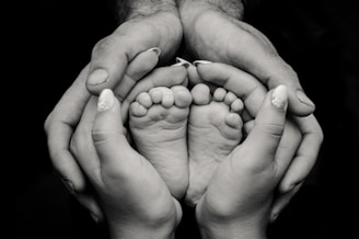 greyscale photography of human feet and hand