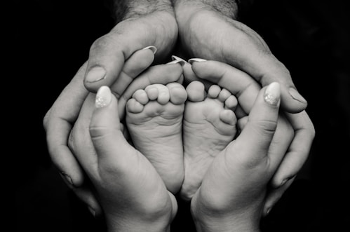 greyscale photography of human feet and hand