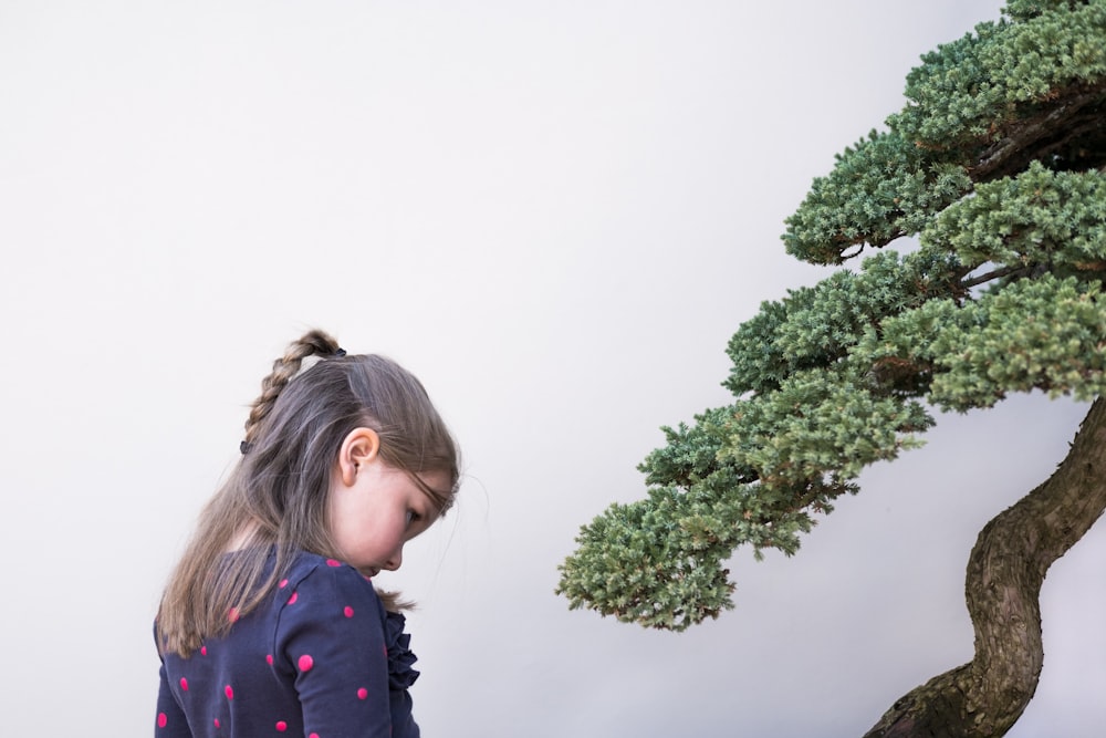 girl standing beside tree