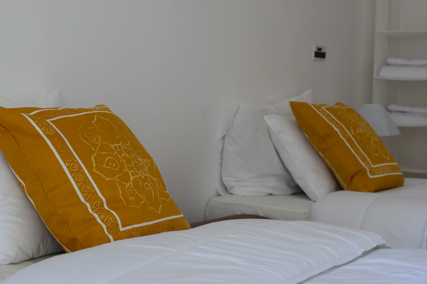 Bed arranged with layered decorative pillows and cushions