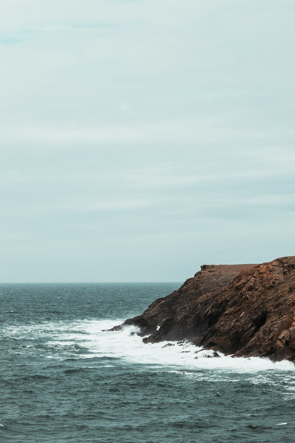 ocean wave splashing on rock during daytime