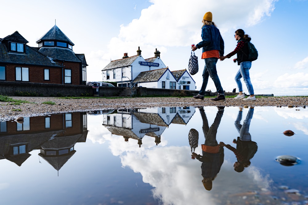 two women walking in front of houses