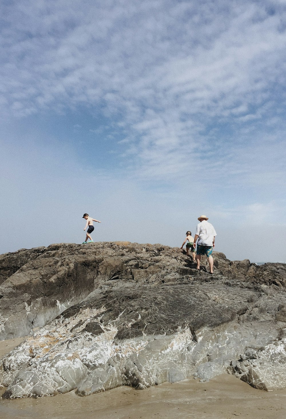 man and two boys walking on rocky mountain