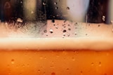 a close up of a glass of beer with drops of water