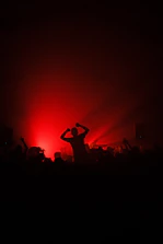 Dynamic shot of a crowd cheering under red glow lights at an ascendspan™ competition.