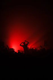 Dynamic shot of a crowd cheering under red glow lights at an ascendspan™ competition.
