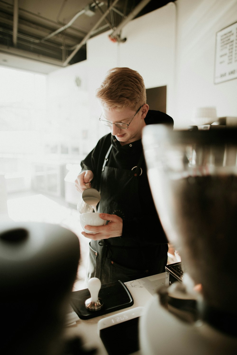 man in black hoodie pouring on white bowl