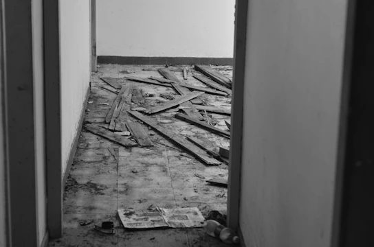 A dark, cramped crawl space showing moisture damage and scattered debris.