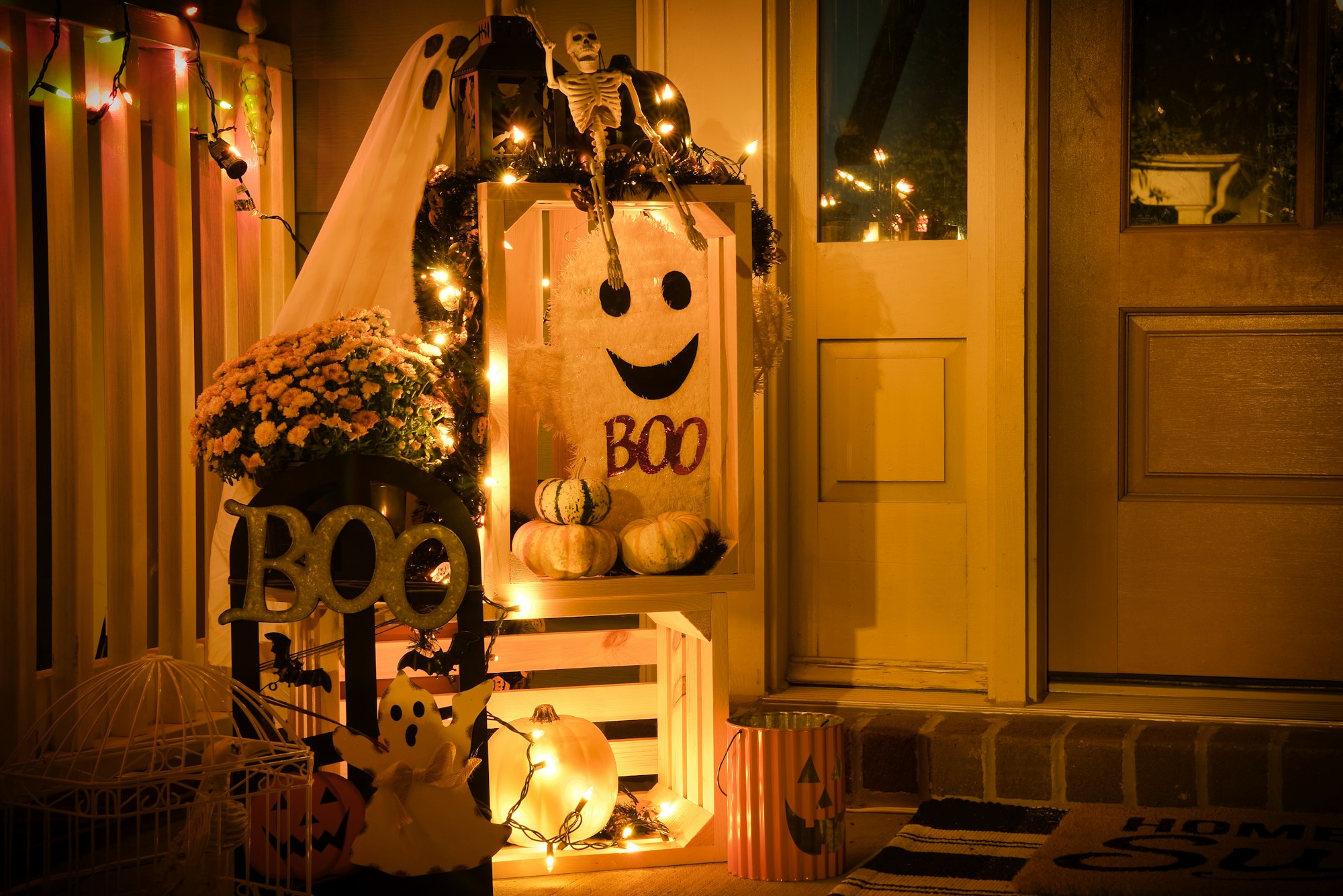 One side of a front porch decorated for Halloween lit up at night