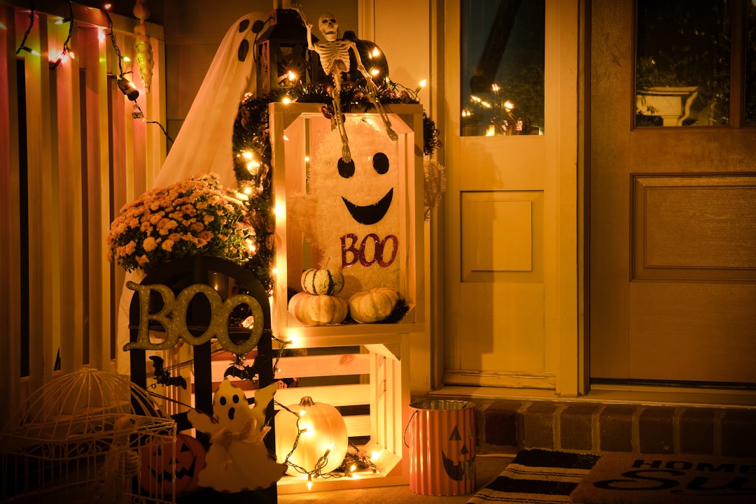 pink flower plant inside room, One side of a front porch decorated for Halloween lit up at night