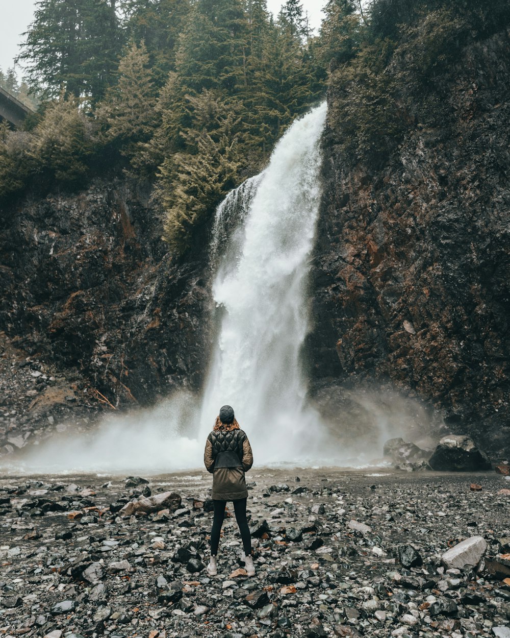 man standing near the waterfalls