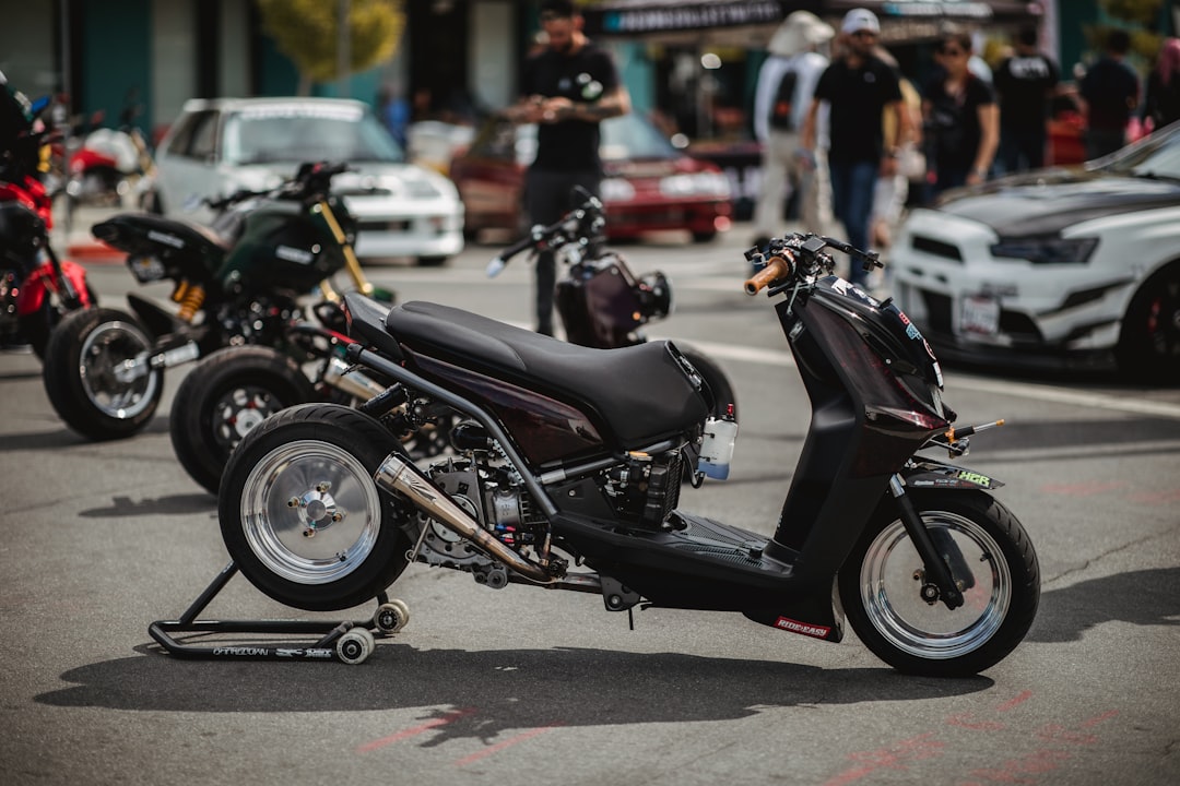 black motor scooter parking near road